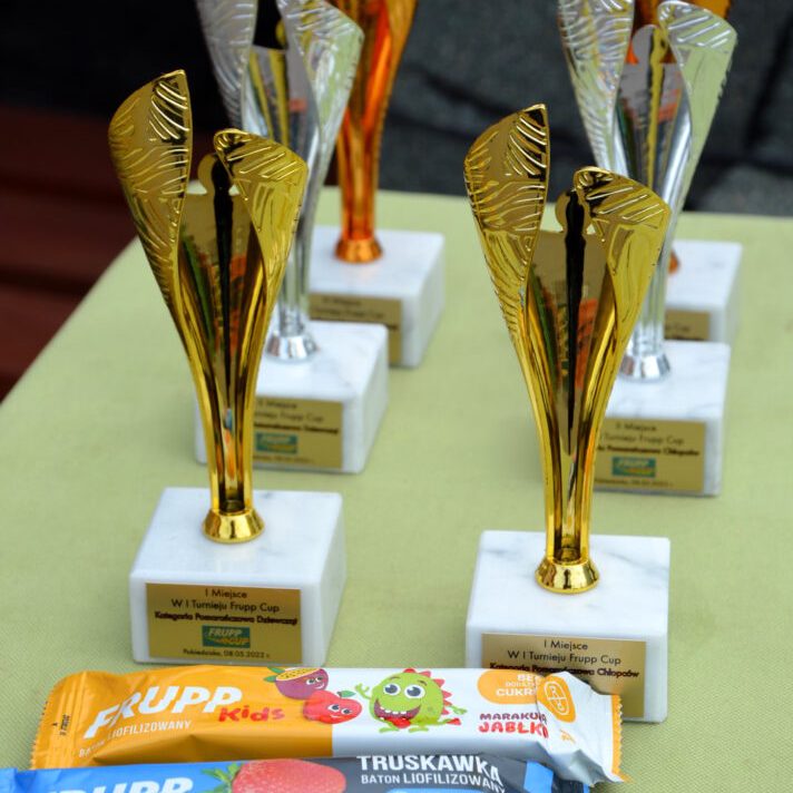 Statuetki nagradzające zwycięzców turnieju FRUPP Cup Tenis 10 oraz batony liofilizowane FRUPP Celiko.